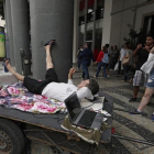Unos turistas ven los Juegos en una calle de Río.-EFE / BARBARA WALTON