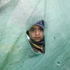 Una niña mira desde el agujero de una tienda en Katmandú, en el Nepal.-Foto:   EFE / NARENDRA SHRESTHA