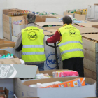 Dos voluntarios trabajan en la sede del Banco de Alimentos.-ISRAEL L. MURILLO