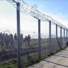 Policías húngaros vigilan a refugiados tras una valla temporal en la frontera con Serbia, cerca de Morahalom, el 22 de febrero del 2016.-ZOLTAN GERGELY KELEMEN