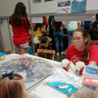 Lucía García Lado explica el proyecto a una niña en Viladecans mediante las maquetas y carteles.-ECB