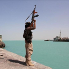 Un militar de las fuerzas gubernamentales respaldadas por Arabia Saudí levanta su arma frente al Mar Rojo, dominado por el otro lado por los huties.-/ SALEH AL OBEIDI (AFP)