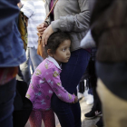 Una niña mexicana con su madre espera con otros inmigrantes en la frontera la respuesta a la solicitud de asilo político en EEUU. /-GREGORY BULL (AP)