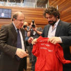 El portavoz de Izquierda Unida, José Sarrión, entrega una camiseta reivindicativa de los trabajadores de Itevelesa al candidato a la Junta de Castilla y León, Juan Vicente Herrera, en el debate de investidura del candidato a la Junta de Castilla y León-Ical