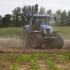 Un agricultor trabaja en la tierra con un tractor agrícola.-RAÚL G. OCHOA