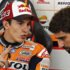 Marc Márquez conversa con un miembro de su equipo en el box de Repsol-Honda, en el circuito de Sepang.-AP / LAI SENG SIN
