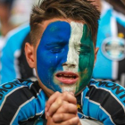 Un aficionado del Gremio llora durante el homenaje al Chapecoense.-AFP / JEFFERSON BERNARDES