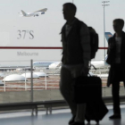 Unos pasajeros caminan con su equipaje en el aeropuerto de Roissy-Charles de Gaulle, en París (Francia).-FRED DUFOUR