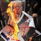Varios palestinos, contrarios a la decisión de presidente Trump, queman su fotografía y banderas estadounidenses.-MOHAMMED SABER (EFE)