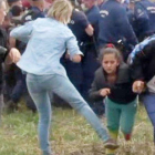 Imagen de un video en la que se ve a la reportera Petra László como hace la zancadilla a una niña refugiada que huye de la policía en el campo de Roszke.-AFP