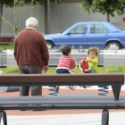 Dos menores juegan en un parque de la ciudad ante la mirada de tres personas mayores.-ISRAEL L. MURILLO