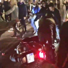 Unos manifestantes tiran a un motorista que no ha querido bajarse de la moto y pretendía continuar su paso, en el paseo de Gracia con la calle Valencia, este miércoles.-GUILLEM SÀNCHEZ