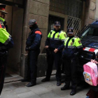 Los mossos saludando a una niña mientras esperan durante en la redada contra los narcopisos en la calle Sant Climent del Raval.-FERRAN NADEU