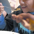 Unos niños en un comedor social de una entidad en el barrio del Raval, en Barcelona.-Foto:  FERRAN NADEU