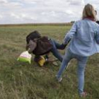 Petra Laszlo le hace la zancadilla a un padre que lleva en brazos a su hijo y una bolsa con sus pertenencias, en Roszke (Hungría).-MARKO DJURICA / REUTERS