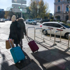 Una pareja de turistas camina por la plaza de Mío Cid, en Burgos, con sus maletas. TOMÁS ALONSO