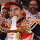 Marc Márquez muerde a lo Rafa Nadal el trofeo del GP de EUU, que ha ganado siempre.-REPSOL MEDIA / JAIME OLIVARES