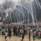Manifestantes palestinos huyen de los gases lacrimógenos lanzados por los soldados israelís.-/ AFP / MAHMUD HAMS