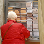 Una mujer busca la papeleta en un colegio electoral, el domingo.-Ical