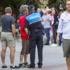 Un agente de la Policía Local realiza unas indicaciones a dos personas.-SANTI OTERO