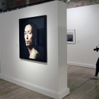 Una fotógrafa pasa por una sala en la que domina el retrato de Pierre Gonnord junto a obras de Castro Prieto (d.) o Enrique Carrazoni (i.).-Raúl Ochoa