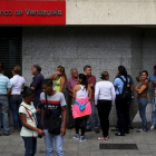 Ciudadanos venezolanos hacen cola en una cajero automático en una sucursal bancaria en Caracas, el viernes.-REUTERS / NACHO DOCE