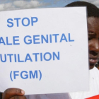 Una mujer sostiene una cartel contra la Mutilación Genital Femenina en una protesta en Kenia.-EL PERIÓDICO