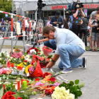 Un hombre deposita flores junto al lugar del ataque.-AFP