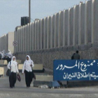 Unas escolares egipcias pasan junto a un cartel que reza "No pasar, abriremos fuego", en el Sinaí.-Foto: AFP