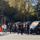 Varias personas saludan a unos agentes de la Policía Nacional, en Barcelona.-JÚLIA REGUÉ