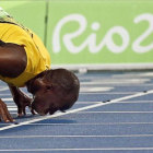 Bolt besa la pista del Estadio Olímpico tras ganar el 200.-EFE / YOAN VALAT