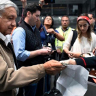 Andrés Manuel López Obrador, presidente de México, recoge su billete de avión antes de embarcar en un vuelo comercial en el aeropuerto internacional de México el 15 de febrero del 2019.-ALFREDO ESTRELLA (AFP)