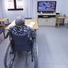 Una persona mayor en situación de dependencia ve la televisión en una residencia de la Diputación.-RAÚL G. OCHOA