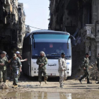 Militares del Ejército sirio supervisan un autobús que transporta combatientes vinculados a Al Qaeda durante una evacuación desde el campo de refugiados palestinos de Yarmuk, cerca de Damasc-SANA / AP