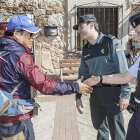 La gendarme Sofía Mateos y un agente de la Guardia Civil saludan a un peregrino en San Juan de Ortega.-SANTI OTERO