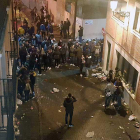Un numeroso grupo de jóvenes concentrados en la calle donde son evidentes los restos de un botellón.-