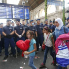 Una familia de refugiados deja la estación más importante de este de Budapest, después de que la policía la cerrara impidiédoles el paso con una valla humana.-REUTERS / LASZLO BALOGH