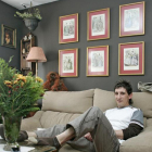 Un joven en el sofá de su vivienda familiar.-ECB