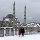 Varios transeúntes caminan por un nevado puente de Galata, en Estambul, este miércoles.-Foto: AFP / BULENT KILIC