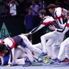 El equipo francés se abalanza sobre Lucas Pouille tras conseguir el punto definitivo sobre Steve Darcis en la final de la Copa Davis.-AP / CHRISTOPHE ENA