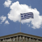 La bandera griega ondea en la Academia de Atenas.-Foto: AP