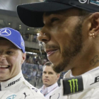 Valtteri Bottas y Lewis Hamilton sonrien tras lograr el finlandés la última pole de la temporada en Abu Dabi.-AP