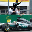 Hamilton celebra el triunfo en Alemania al paso frente a sus mecánicos.-AFP / THOMAS KIENZLE