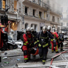 Los bomberos trasladan a una herida en la explosión en una panadería en París, este sábado.-AFP