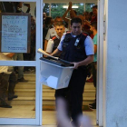 Un mosso se lleva una urna de un colegio durante el referéndum del 1-O.-RICARD CUGAT