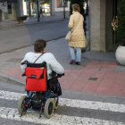 Una persona en silla de ruedas cruza un paso de cebra.-SANTI OTERO
