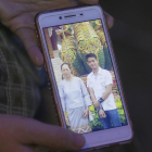 La tia de Ekapol Chanthawong muestra una foto en el móvil del entrenador en la que aparace junto a su abuela.-AP