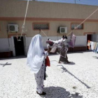 Una mujer tiende la ropa en una cárcel de Trípoli, en Libia.-REUTERS