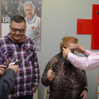 Juan Carlos y Carmen reciben sus gafas de manos del presidente de Cruz Roja en Burgos y del óptico de Multiópticas.-ECB