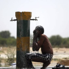 Un trabajador indio se refresca bajo un grifo una calurosa tarde en Amritsar (India).-Foto: EFE / RAMINDER PAL SINGH